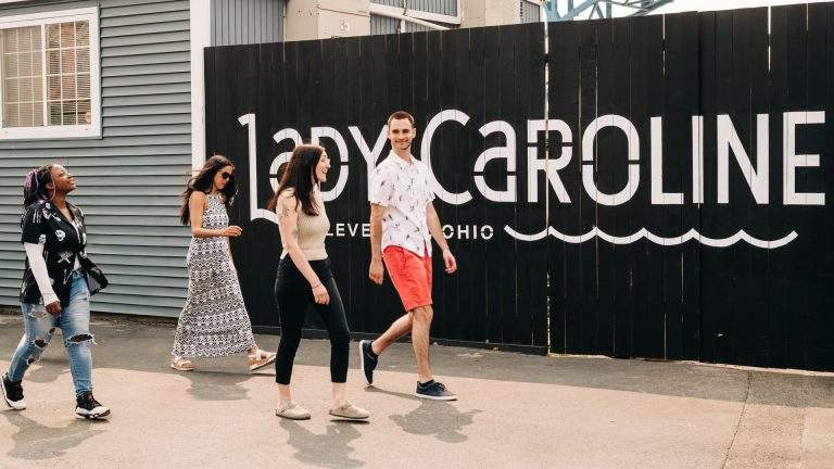 Group of employees walking up past Lady Caroline offices